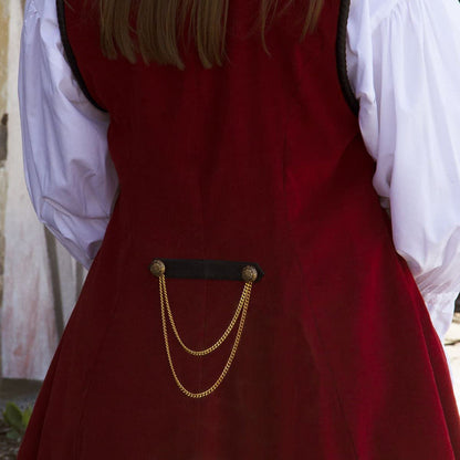 red corduroy sleeveless coat with pleated duck-tail, faux black leather collar and shoulder accents, gold buttons and trim